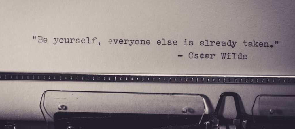Vintage typewriter displaying Oscar Wilde's quote 'Be yourself, everyone else is already taken.'
