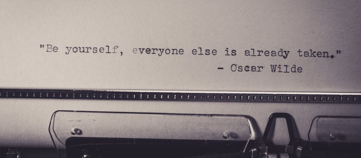 Vintage typewriter displaying Oscar Wilde's quote 'Be yourself, everyone else is already taken.'