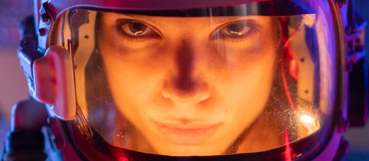 A focused female astronaut in a futuristic space suit, ready for interstellar exploration.