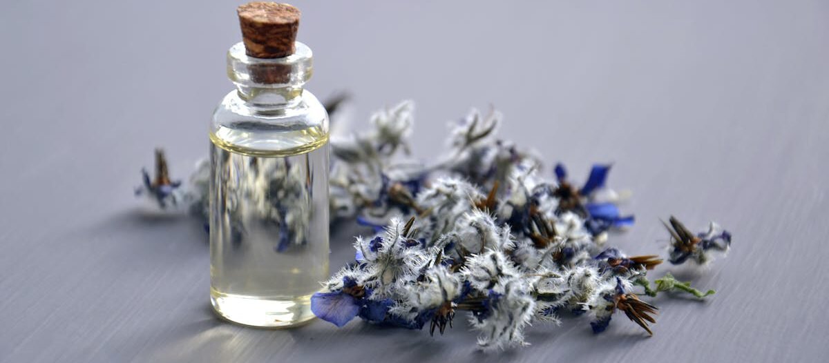 Close-up of a lavender oil bottle with dried flowers for aromatherapy. Perfect for wellness themes.